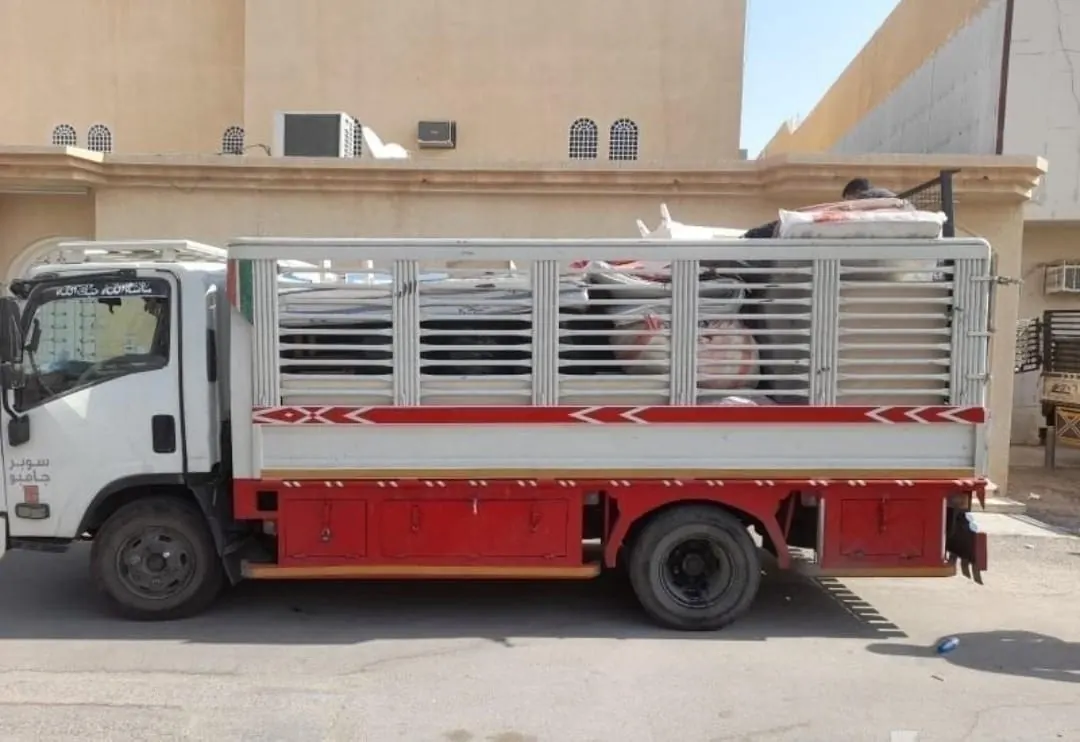 عمال نقل عفش بالرياض أثناء تحميل الأثاث المغلّف داخل الشاحنة